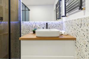 baño con lavabo blanco en una encimera de madera en Apartamenty KTW, en Katowice 31 fotos más