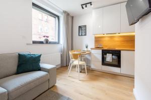una sala de estar con un sofá y una mesa en Apartamenty KTW, en Katowice