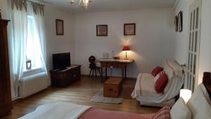 een slaapkamer met een bed, een bureau en een televisie bij La maison de Lili in Guebwiller