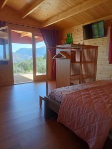 a bedroom with a bed and a large window at Cabañas by Torre de Arriba in Benimantell