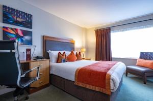 une chambre d'hôtel avec un lit et une chaise dans l'établissement Bermondsey Square Hotel - A Bespoke Hotel, à Londres