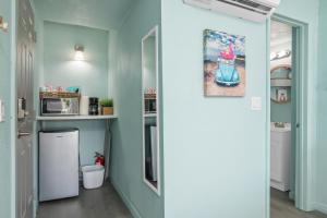 a kitchen with blue walls and a white refrigerator at Latitude 26 Waterfront Boutique Resort - Bonita Springs in Bonita Springs