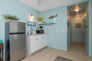 a kitchen with a refrigerator and a sink at Latitude 26 Waterfront Boutique Resort - Bonita Springs in Bonita Springs