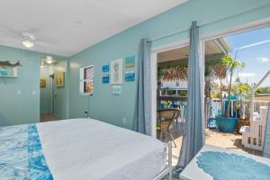 1 dormitorio con 1 cama grande y balcón en Latitude 26 Waterfront Boutique Resort - Bonita Springs en Bonita Springs