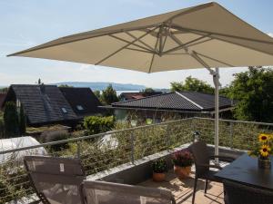 une terrasse avec une table et un parasol dans l'établissement Über der alten Gärtnerei, à Allensbach