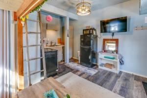 a kitchen with a refrigerator and a tv on a wall at Fairbanks Vacation Rental Studio Near Downtown! in Fairbanks