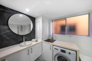 een badkamer met een wastafel en een wasmachine bij Newly Renovated Unit in Southport Gold Coast in Gold Coast