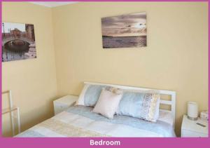 a bedroom with a bed with three pictures on the wall at Estuary Parade House in Ross River