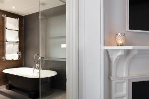 ein Bad mit einem Waschbecken und einer Glasdusche in der Unterkunft The Chesterfield Suite in London