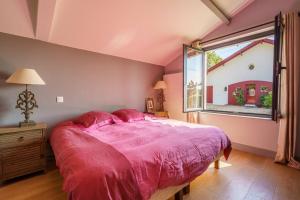 a bedroom with a large pink bed and a window at Dépendance paisible proche Océan in Arbonne