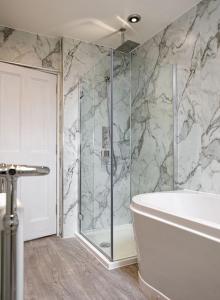 a bathroom with a shower and a bath tub at Conon Hotel in Dingwall