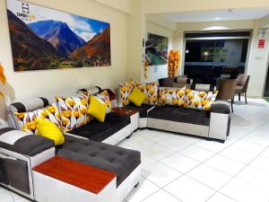 una sala de espera con sofás y almohadas amarillas en Hostal Tambo Alto en Churín