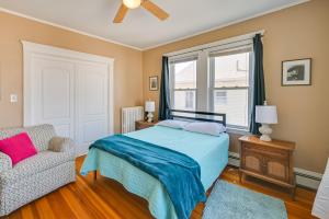 a bedroom with a bed and a chair and a window at Revere Vacation Rental Near MBTA about 7 Mi to Boston! in Revere