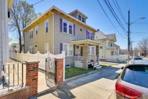 una casa amarilla con una valla blanca en una calle en Revere Vacation Rental Near MBTA about 7 Mi to Boston!, en Revere