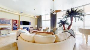 a living room with a white couch and a piano at Turquoise Place 2304D in Orange Beach