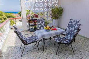 d'une table et de chaises avec un bol de fruits sur le balcon. dans l'établissement Zoumperi Nea Makri 4-5 guest apt big balconies 5 min to beach, à Nea Makri