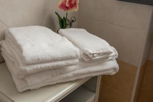 a pile of white towels sitting on a shelf in a bathroom at Casa Victoria in Galleno
