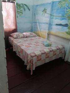 - une chambre dotée d'un lit avec une couverture rouge et blanche dans l'établissement El Jaguar, à Bocas del Toro