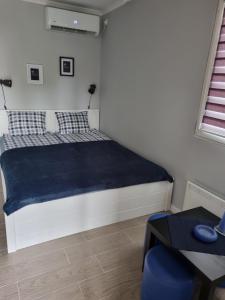 um quarto com uma cama com um cobertor azul em Apartman 27 Palic em Palić