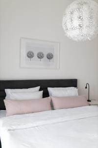 1 dormitorio con 1 cama con almohadas rosas y blancas en A 207-Fruske Residence, en Vrdnik