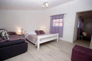 a bedroom with a white bed and a couch at Apartments D in Premantura