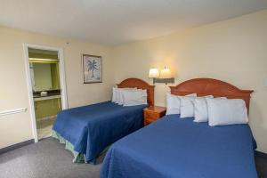 a hotel room with two beds with blue sheets at Oceanfront 2 Bedroom 3 Bathroom Unit 539-540 - Sleeps 10 in Myrtle Beach +59 photos