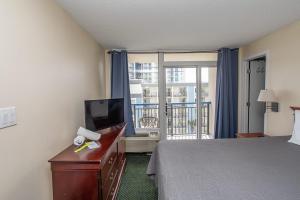 a hotel room with a bed and a flat screen tv at Oceanfront 2 Bedroom 3 Bathroom Unit 539-540 - Sleeps 10 in Myrtle Beach