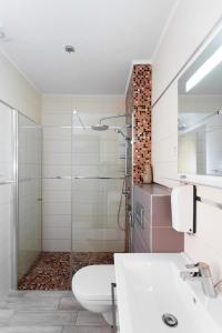 a bathroom with a shower and a toilet and a sink at Altezza Premium Breathtaking Sea Views in Budva +81 photos