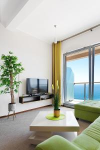 a living room with a couch and a tv and a window at Altezza Premium Tophill best view and pool in Budva