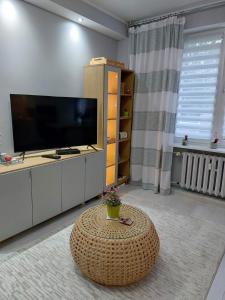 sala de estar con TV grande y mesa en Bee Happy Apartament Wrzesnia, en Września