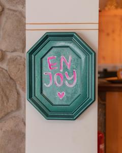 a green sign that says en joy on a wall at Sylvana's Wohlfühl Hotel in Mayrhofen