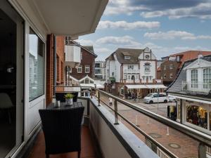 a balcony with two chairs and a view of a street at Traumkoje im Herzen Westerlands strandnah Meer in Westerland (Sylt)
