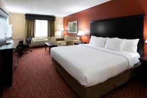 a hotel room with a large bed and a desk at GrandStay Hotel & Suites in Cambridge