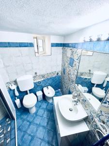 ein blau-weißes Badezimmer mit 2 WCs und einem Waschbecken in der Unterkunft Relax nel Centro Storico in San Nicola Arcella