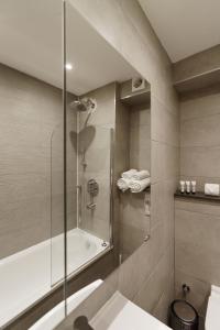a bathroom with a shower and a sink and a tub at Penywern Apartment Earls Court in London
