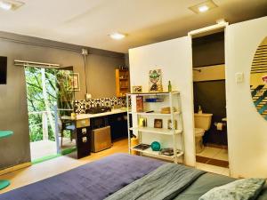 um quarto com uma cama e uma cozinha com um lavatório em Beautiful house surrounded by nature with deck em Medellín