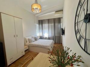 Habitación pequeña con cama y reloj en la pared en Apartments 4 Karla, en Zagreb
