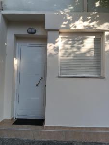 a white building with a door and a window at Studio Jim in Volos