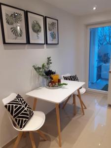 a dining room with a white table and chairs at NEW - Apartment Kameni Confort Wifi Munich Airport Family in Neufahrn bei Freising
