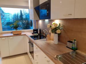 a kitchen with a vase of flowers on the counter at NEW - Apartment Kameni Confort Wifi Munich Airport Family in Neufahrn bei Freising