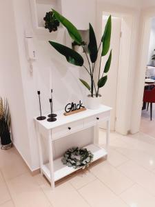 a white table with potted plants on top of it at NEW - Apartment Kameni Confort Wifi Munich Airport Family in Neufahrn bei Freising