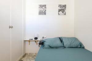 uma cama num quarto com duas fotografias na parede em Elegant Apt. for 6 in Murcia with AC and WIFI em Múrcia