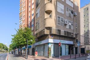 a person walking down a street in front of a building at Elegant Apt. for 6 in Murcia with AC and WIFI in Murcia