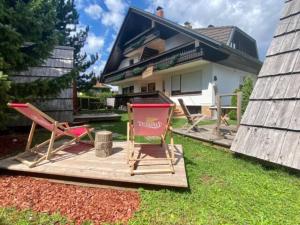 um grupo de cadeiras sentadas num deque em frente a uma casa em Glamping houses J-Max em Bled