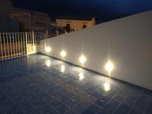 a wall with lights on the side of a building at Archè in Syracuse