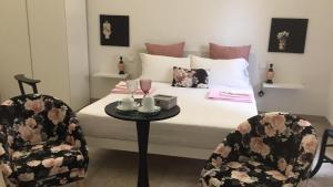 a bedroom with a bed with a table and two chairs at Archè in Syracuse