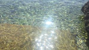 a view of the water with the sun reflecting in it at Archè in Syracuse