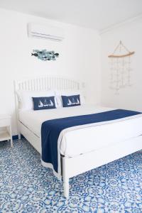 una camera con un grande letto blu e bianco di La Casetta a Capri