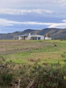 a barn in the middle of a field at Ou Werf Farm Cottage in Bredasdorp