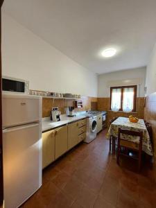 ポルト・アッズッロにあるCasa Azzurra vacanze Porto Azzurroのキッチン(冷蔵庫、テーブル付)